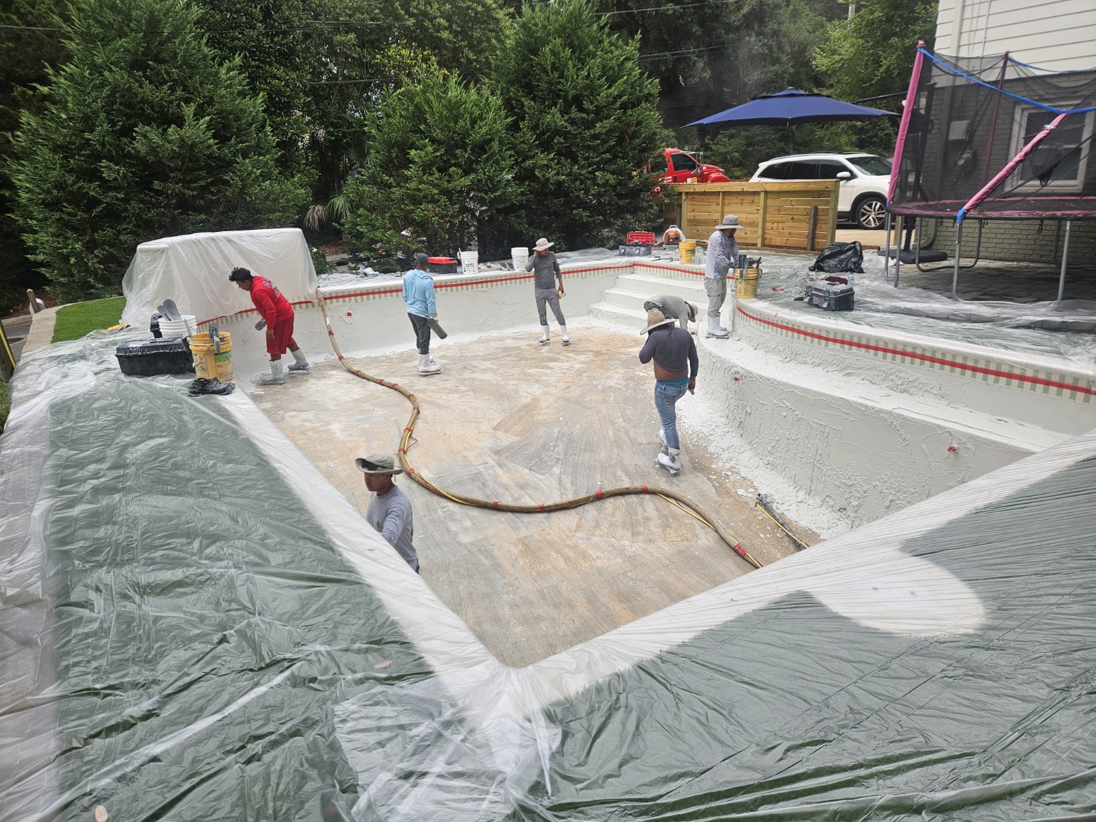 Pool finish craftsmen applying interior pool finish by hand