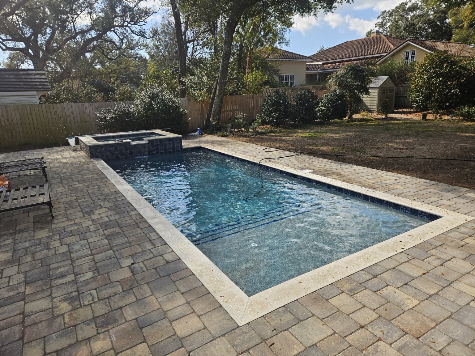 Geometric pool and raised spa with paver deck